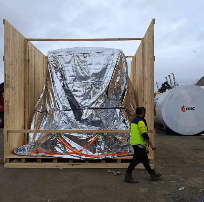 wooden shipping crate with worker in high vis